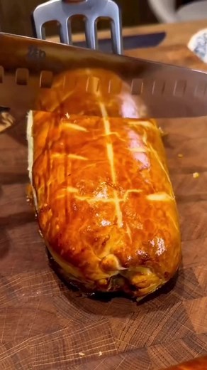 Slicing a Flaky Golden-Brown Pastry with Juicy Filling