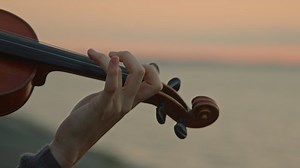 clip-1081077860-young-musician-playing-fiddle-bowing-along-strings