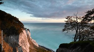 Time lapse: sunrise landscape of the magnificent chalk cliffs of Møns Klint, rising high above the Baltic Sea. Clouds moving over the turquoise waters of the Baltic Sea. Denmark's highest cliff.