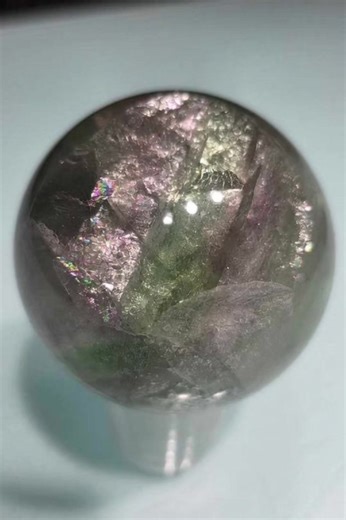 This mesmerizing fluorite sphere displays layers of soothing greens, purples, and crystal-clear hues, polished into a perfect orb that radiates harmony and balance. Known as the stone of focus and clarity, fluorite is believed to calm the mind, organize thoughts, and shield against negative energy. The sphere shape allows its energy to flow evenly in all directions, making it ideal for meditation, study spaces, or as a beautiful centerpiece in your crystal collection. Both elegant and powerful, 