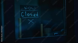 Electric blue handwriting on blackboard in window says now closed in room