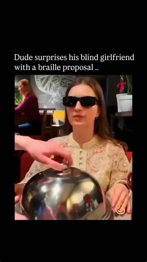 INFYKO on Instagram: "The post shares a viral video from 2024 depicting a man proposing to his blind girlfriend by arranging coins into Braille on a plate to spell "Will you marry me?", evoking widespread emotional responses with over 20,000 likes and heartfelt replies praising its thoughtfulness. While some online discussions, including Reddit threads and X replies, question its authenticity—citing scripted elements or prior circulation since at least 2016—the clip originates from genuine viral