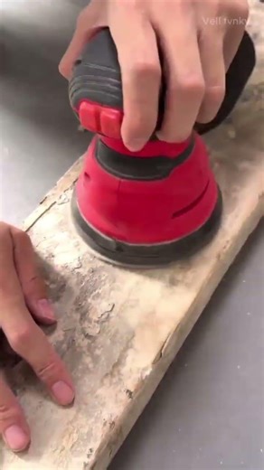 Cleaning residue of cement from surface of wooden plank using electric chisel tool in the workshop