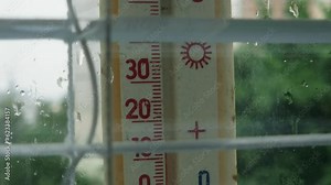 Outdoor thermometer with Celsius scale attached to window, inside view
