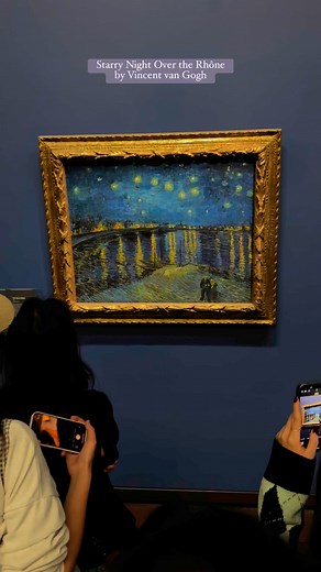 “Starry Night Over the Rhône” by Vincent van GoghInside Musée d’Orsay, Paris. Wow. Just look at it. This painting shows a magical night in Arles, France, where stars sparkle above the Rhône River and city lights dance on the water. Van Gogh painted this in 1888 — not just what he saw, but what he felt. The sky is alive, glowing with stars, and the river reflects it all like a mirror. Two tiny people walk by, quietly enjoying the view — maybe like us. What’s amazing is how he used just paint and