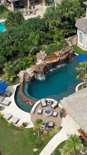 We not only created an amazing pool, but we also created the ultimate outdoor living space with so many features: a tiki Hut, a hidden water slide, spa, massive grotto, sun shelf, infinity edge, firepit, and the list goes on. #insanepools #lucaslagoons #pool #backyard | Lucas Lagoons