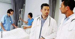 Two doctors discussing over medical report while nurse examining a patient