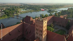 Malbork,Poland.Aerial 4K video from drone to Medieval Malbork ( Zamek w Maborku, Ordensburg Marienburg ),castle in Poland fortress of the Teutonic Knights at the Nogat river in sunrise light.(Series)