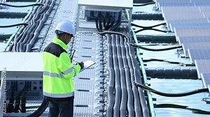 Asian engineer working at Floating solar power plant,Renewable energy,Technician and investor solar panels checking the panels at solar energy installation