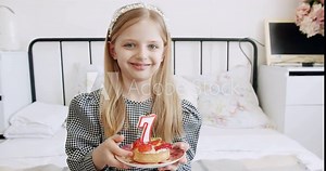 A birthday party for a happy cute 7 year old girl and blowing candles on a cake. Celebrating the occasion. Happy 7 year old girl with birthday party cake. Celebrating Birthday party at home.