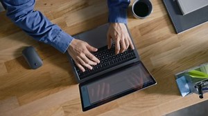 Top View Rotating Shot: In the Office Businessman Sitting at the Wooden Desk Opens Laptop and Starts Working He Drinks Coffee, Types, Writes Emails, Surfs the Internet, Designs Software