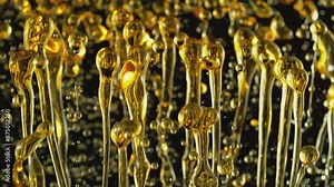 Super Slow Motion of Splashing Oil Drops on Black Background. Filmed on High Speed Cinema Camera, 1000fps. Abstract Golden Oil Splashes, Beauty or Cooking Concept. Speed Ramp Effect.