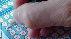 Pen markings on lottery ticket. Someone checks the lottery numbers 6 - 28 - 19