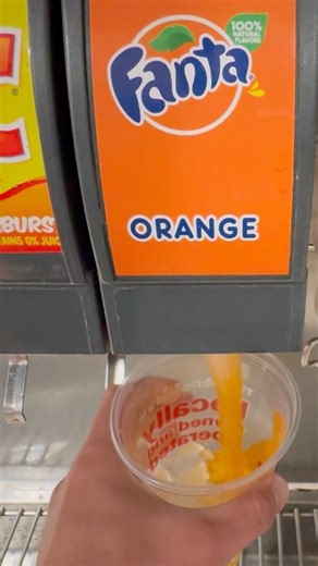 getting orange Fanta soda drink refill at McDonald’s soda fountain machine