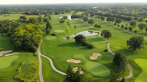 Top view of the golf course, players and employees of the golf club are on the course, everyone is doing their own thing. Aerial view of the green golf course.