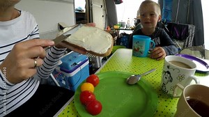 Summer time in the Austrian alps. Breakfast at the campsite. Mother preparing healthy food for family. Stabilized footage.