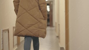 Slow motion of elegant woman walking at hotel narrow hallway corridor