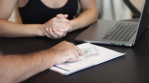 Close-up People talk about building construction at meeting table with house model. Chief Architect Presenting Building Construction plan. Real Estate Architectural Conference Meeting.