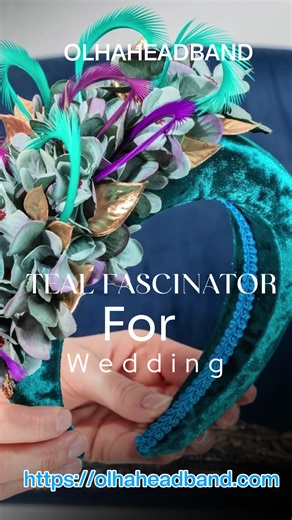 Make a bold statement at your next wedding with this luxurious padded fascinator headband. Handcrafted with a rich teal velvet base, it features a stunning arrangement of fabric hydrangea petals, metallic gold leaves, and vibrant peacock-style feathers. This crown-like headpiece perfectly balances vintage elegance with modern flair, making it the ultimate accessory for a sophisticated wedding guest or a day at the races. #WeddingGuestStyle #FascinatorHeadband #WeddingFashion2026 #RoyalAscotStyle