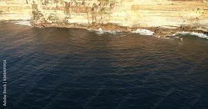 Surface of rolling waves hitting and undermining sandstone cliffs of Sydney eastern suburbs around south head under Macquarie lighthouse.