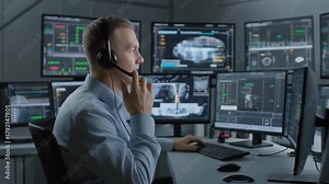 Control room operator monitors complex data on multiple screens in a high-tech environment