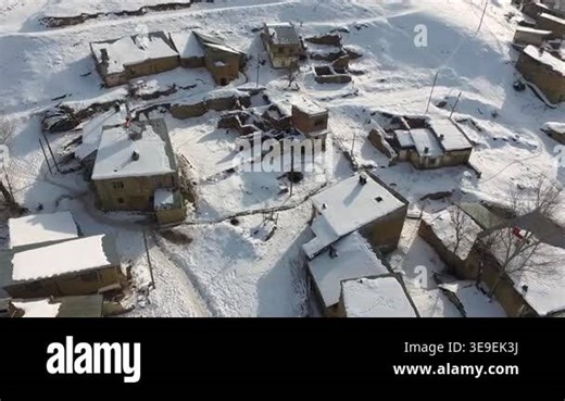 Aerial snowy traditional poor village houses across rural Pakistan in winter across rural terrain. Cold season geography reveals settlement living and housing patterns seen clearly from above. fields, india, pakistan geography, jammu.