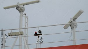 GPS and navigational instruments spinning on top of a white ship at sea.