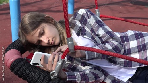 Girl Playing Smartphone in Swing, Teenager Kid Browsing Internet on Smart Phone in Park, Adolescent Child Outdoor at Playground