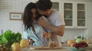 Lovely couple flirting at home. Sensual woman flirting with man at kitchen