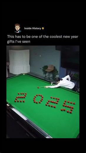 Inside History on Instagram: "An intricate billiards trick shot features dozens of red balls carefully arranged on a pool table to spell “LOVE,” with a white cue ball set for the break. As the player strikes with precise force and angle—punctuated by a French voice declaring “C’est parti!”—the balls explode into controlled motion, then astonishingly settle into the numbers “2025,” marking a symbolic New Year transition into 2026. The feat blends artistry with physics, relying on elastic collisio
