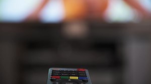 Download 4K video of TV remote control with TV in background for free