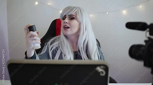 Female video blogger is reviewing cosmetics in front of a professional camera