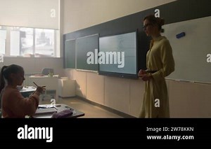 Female teacher standing at blackboard in front of class full of children Stock Video Footage - Alamy