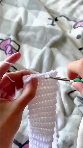 Crocheting a pink and white soft yarn project with a hook for a unique and stylish handmade design
