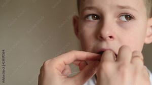 a mother loosens and tries to pull out a baby tooth to a small child boy using dental floss.