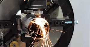 Automated programmed machine for metal processing. Industrial laser machine cuts out parts in sheet steel. Heat. Sparks during operation of production machine at factory.