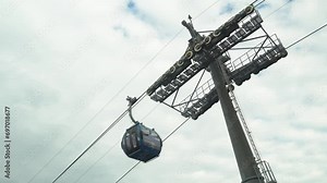 Blue funicular cable car offers a scenic touristic ride to reach destination, against sky background. Public transportation and recreational experience, perfect vacation