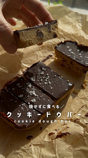 ぽの|ごきげん10分レシピ on Instagram: "焼かずに食べるクッキー/クッキードウ 焼く前のクッキー生地を食べたい！ そんな夢を叶えてくれたのが、海外で大バズりした『クッキードウ』のレシピ✨ ぜひ作ってみてね☺️ 材料 ⏰作業時間5分 ・クッキードウ生地 ◽️アーモンドフラワー:100g ◽️無塩ピーナッツバター:40g ◽️メープルシロップ:40g ◽️ココナッツオイル:小さじ2 ◽️お好きなチョコチップ、チョコを砕いたもの:30g ・チョコレートバーにする場合 ◽️お好きなチョコ:70g（高カカオがオススメ） ◽️ココナッツオイル:小さじ2 作り方 ①クッキー生地の材料全部混ぜたら完成🤣 ②動画のようにチョコレートバーにする場合は、①のクッキー生地をお好きな型に入れ、しっかりと押し固める ③お好きなチョコ70gをレンチンなどで溶かし、ココナッツオイルと合わせて型に流し入れる ④冷蔵庫で冷やしてチョコが固まればOK 💡ポイント ⭐︎チョコレートバーにする場合はしっかりと型に押し固める ＿＿＿＿＿＿＿＿✻✻✻＿＿＿＿＿＿＿＿�＼誰でもかんたんに作れる／�おやつ作りを始め