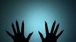 Witch hands with long sharp nails scratching glass, horrifying scene, creepiness. Blood-chilling horror thriller shot