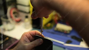 Learn effective phone repair techniques as skilled technicians disassemble and fix a smartphone in a well-equipped workshop.