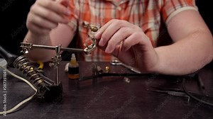 Process of replacing cable for audio rca connector. Muscled electrician solder wire with rosin soldering iron to male jack rca. Stock Video