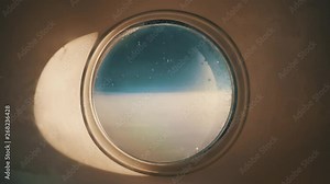 Airplane window timelapse of flying over the clouds during a beautiful sunset. Shadow moves from the window and distant deep blue skies go on infinitely. Shot in 4k