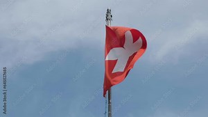 Swiss flag, white cross on red background in slow motion. Switzerland, texture, fabric.