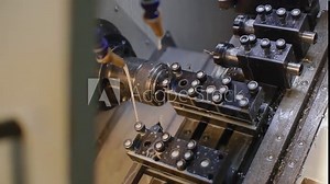 Change of position of the workpiece. The operation of CNC lathe machine with multi-function operation. Hi-technology manufacturing process. Сutting fluid.