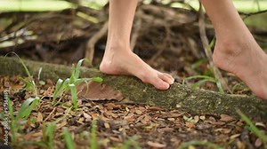 Lonely Girl feet without shoes walking on the big tree root in the park