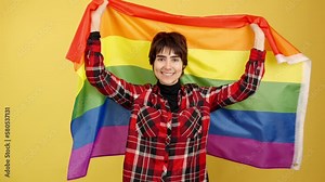Androgynous person raising a lgbt rainbow flag Stock Video