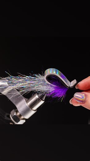 Erin Hyde on Instagram: "Oh, the iridescence! Gurglers are floating flies meant to create a surface disturbance that mimics struggling prey or feeding baitfish. With the holographic elements and the purple @Fulling_Mill Leggy Voodoo Brush for some much needed contrast, it’s safe to say this one certainly makes a scene! 💙 Visit the “Fly Recipes” section of my website for a full ingredient list & check out the full process video on YouTube (links in bio)! Fly: Holographic Gurgler Tied by: Erin Hy