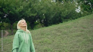 Senior woman playing tennis on in the park. An active and beautiful grandmother actively spends time in nature. The old woman is smiling. High quality 4k footage