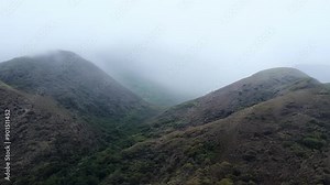 Fog descending upon the rugged hills creating an ethereal atmosphere.