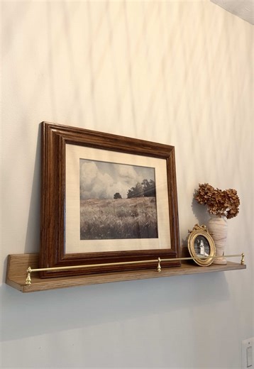 Turned this plain entryway wall into a cute display for unused decor on a budget! This gallery rail shelf diy was done all for around $30! Shelf is from Target and the gallery rail hardware is from Amazon! note: the shelf is not real wood so I just glued the railing hardware since it isn’t weight bearing #diydecor #pictureshelf #budgetfriendlydecor #galleryrail